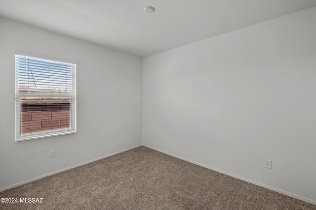 unfurnished room featuring carpet floors and baseboards