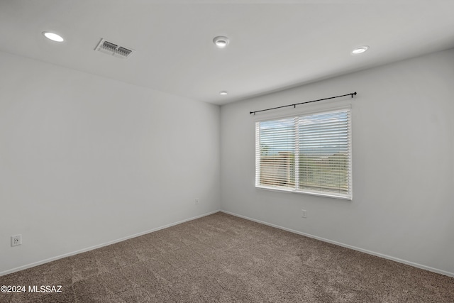 carpeted empty room with baseboards, visible vents, and recessed lighting