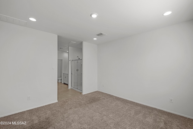spare room with light carpet, visible vents, and recessed lighting