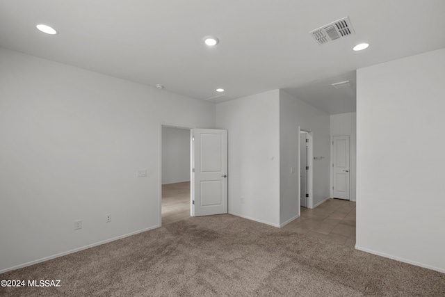 carpeted spare room featuring recessed lighting, baseboards, and visible vents