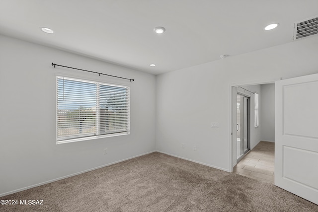 unfurnished room featuring recessed lighting, light carpet, baseboards, and visible vents