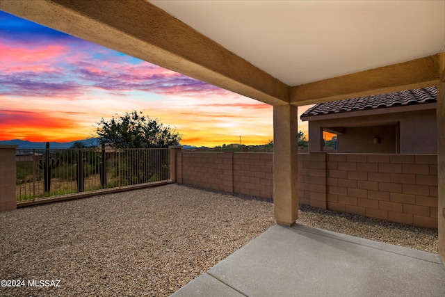 view of yard featuring fence, a mountain view, and a patio area