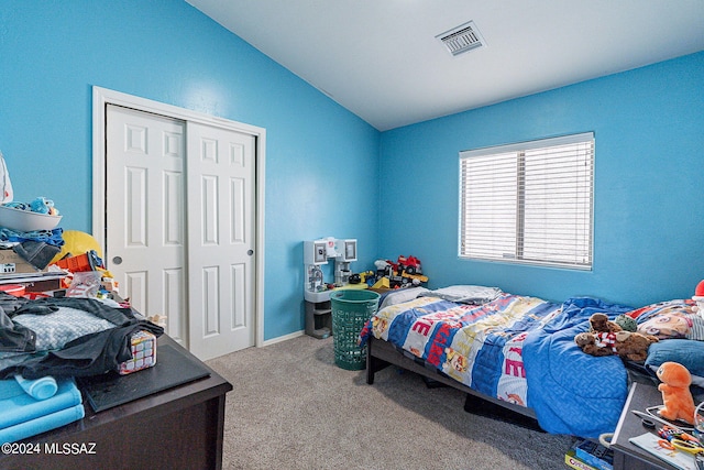 bedroom with vaulted ceiling, carpet floors, and a closet