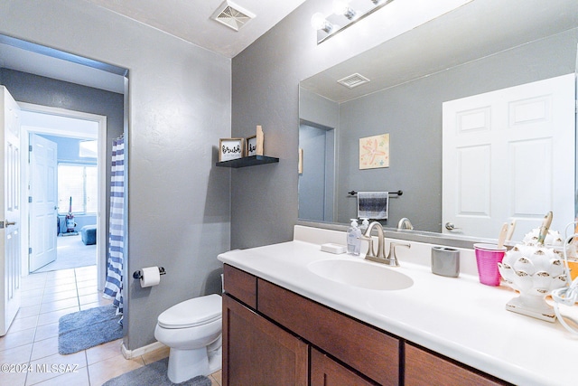 bathroom with tile patterned floors, vanity, and toilet