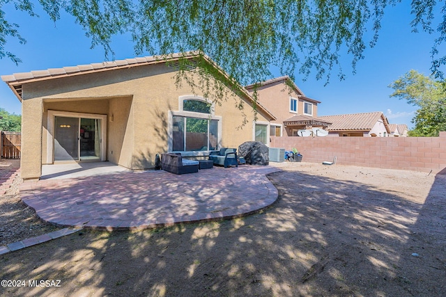 back of property featuring an outdoor living space, central air condition unit, and a patio area