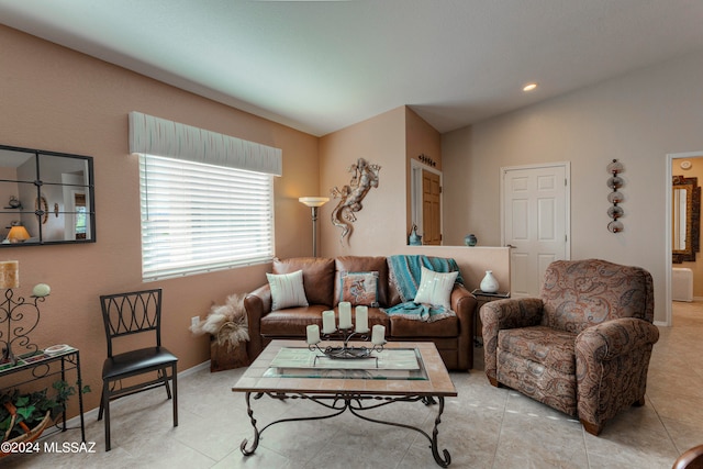 living room with light tile patterned floors and vaulted ceiling