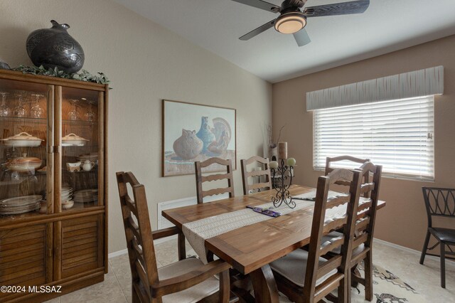 dining space with light tile patterned flooring, vaulted ceiling, and ceiling fan