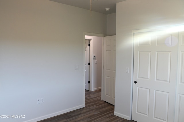 unfurnished bedroom featuring dark hardwood / wood-style flooring and a closet