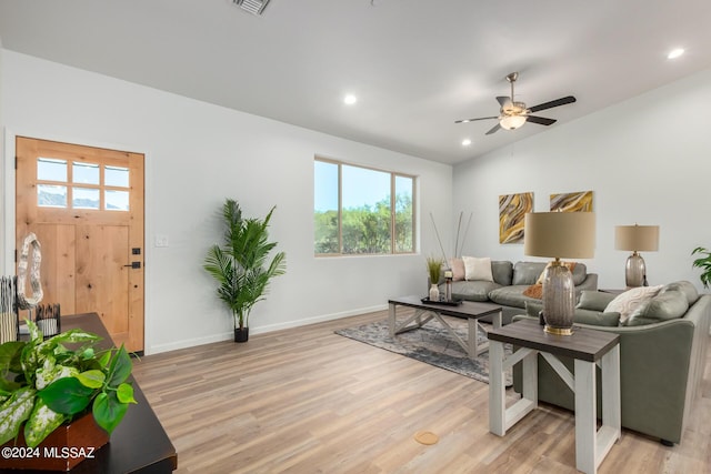 living room with light hardwood / wood-style floors, ceiling fan, and lofted ceiling