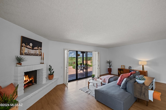 living room with a fireplace, hardwood / wood-style floors, and a textured ceiling