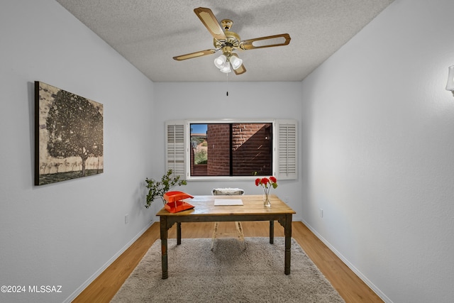 home office featuring ceiling fan, a textured ceiling, and hardwood / wood-style flooring