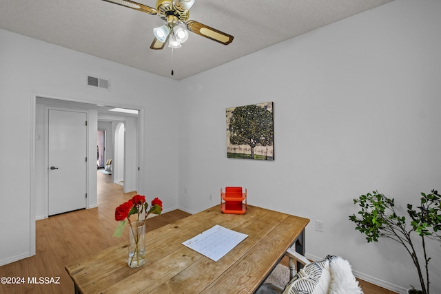 dining room featuring hardwood / wood-style flooring, ceiling fan, and a textured ceiling