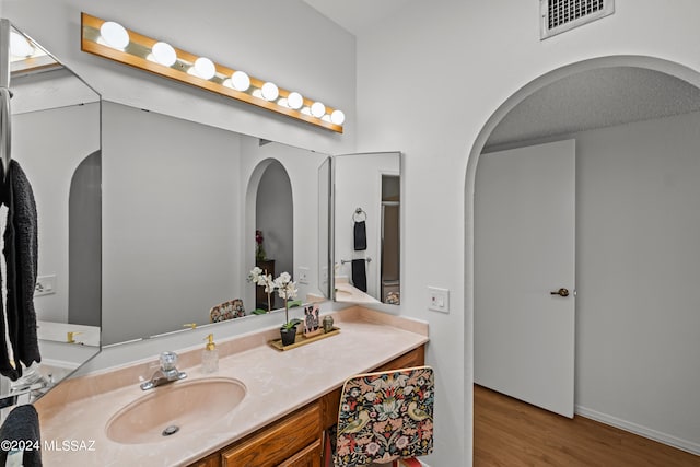 bathroom featuring wood-type flooring, vanity, and a textured ceiling