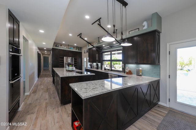 kitchen featuring decorative backsplash, light wood-style flooring, appliances with stainless steel finishes, a center island, and dark brown cabinets