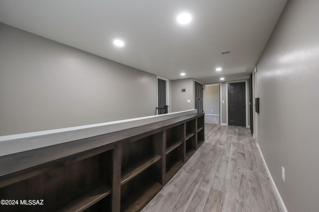 hallway with light wood-style floors, recessed lighting, visible vents, and baseboards