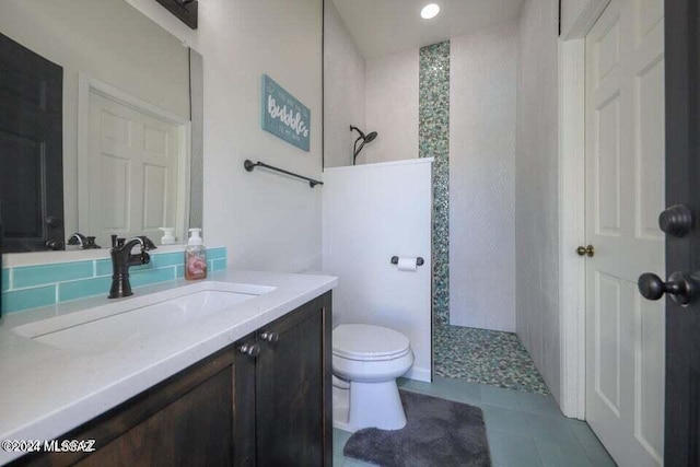 bathroom with tile patterned floors, vanity, toilet, and walk in shower