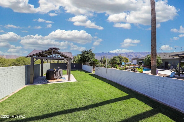 view of yard with a patio area, a mountain view, a fenced backyard, and a gazebo