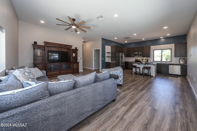 living area featuring dark wood-style floors, baseboards, visible vents, and recessed lighting