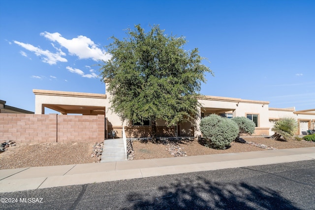 view of front of property featuring stucco siding and fence