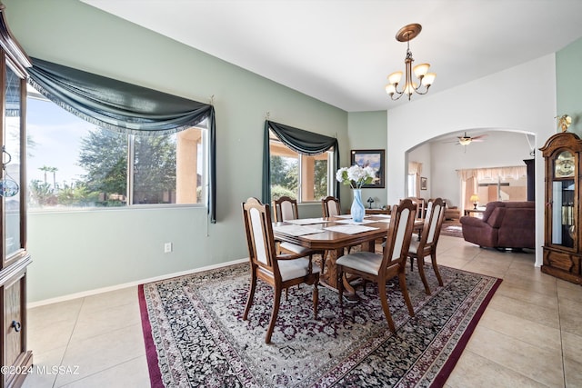 dining area featuring arched walkways, baseboards, an inviting chandelier, and light tile patterned floors