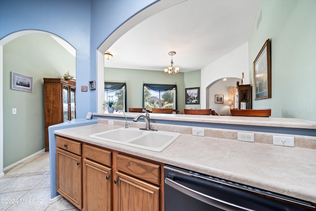kitchen featuring light countertops, a chandelier, stainless steel dishwasher, a sink, and arched walkways