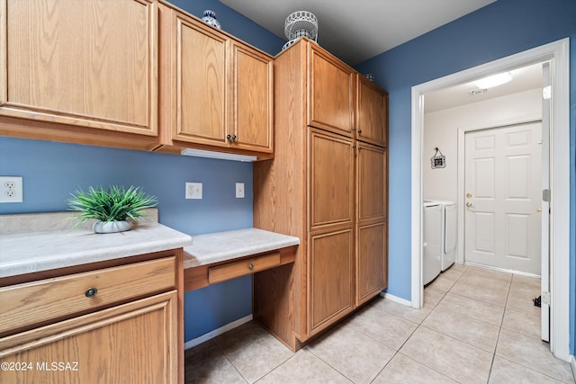 kitchen with washer and clothes dryer, light countertops, light tile patterned floors, baseboards, and built in desk