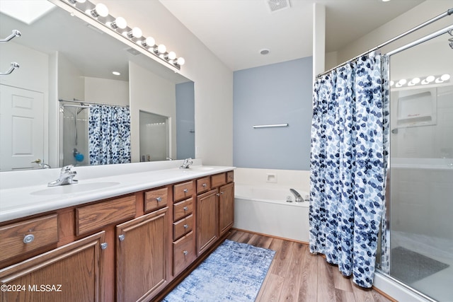 bathroom with a sink, a stall shower, visible vents, and wood finished floors