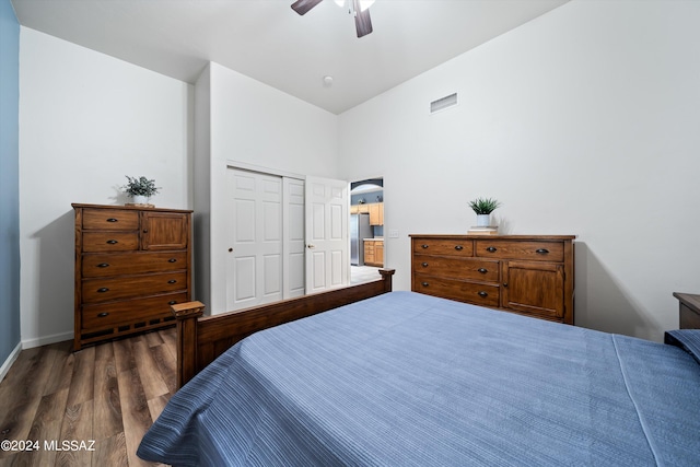bedroom featuring a closet, visible vents, ceiling fan, dark wood finished floors, and freestanding refrigerator