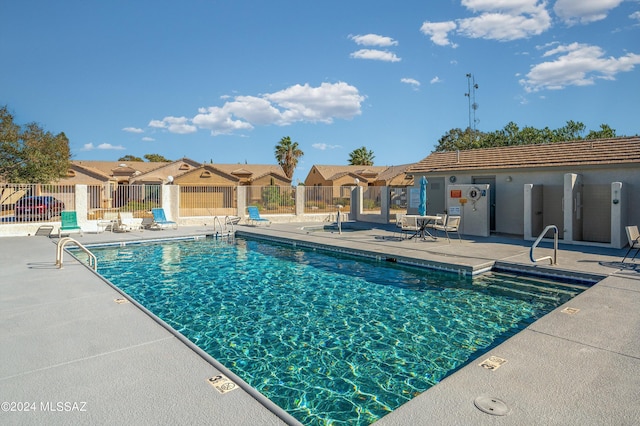 pool featuring fence, a residential view, and a patio area