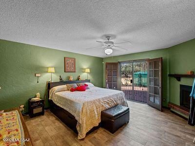 bedroom with light hardwood / wood-style flooring, a textured ceiling, access to exterior, and ceiling fan