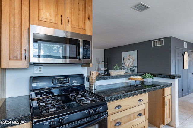 kitchen featuring light tile patterned floors and black gas range