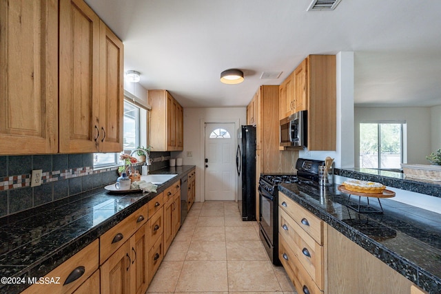 kitchen featuring light tile patterned flooring, backsplash, sink, and black appliances