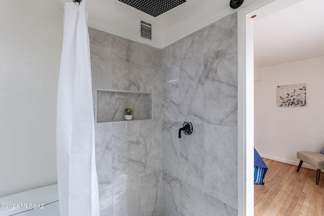 bathroom with hardwood / wood-style flooring and a shower with shower curtain