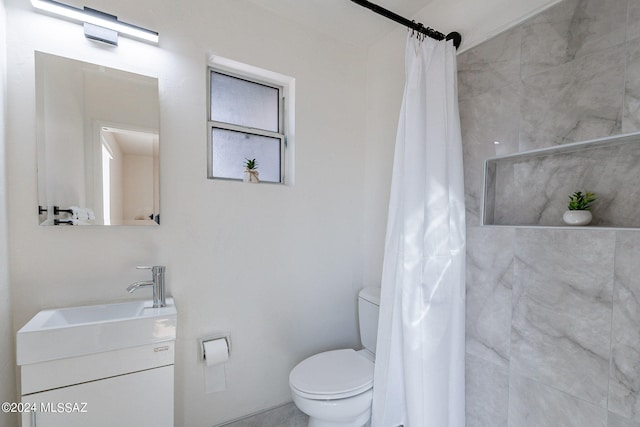 bathroom featuring vanity, toilet, and a shower with shower curtain