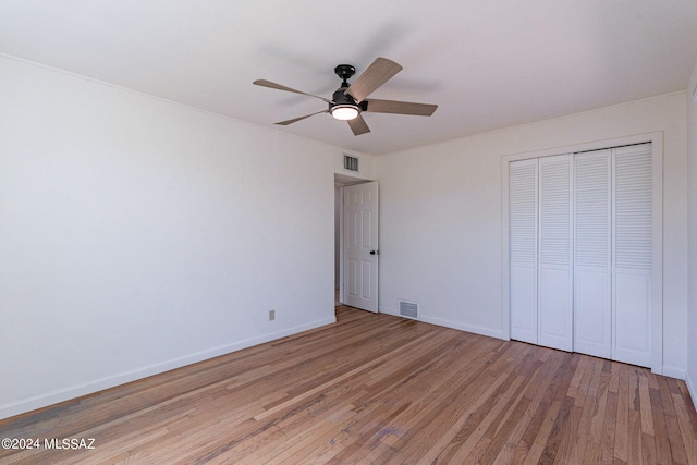 unfurnished bedroom featuring ceiling fan, light hardwood / wood-style flooring, and a closet