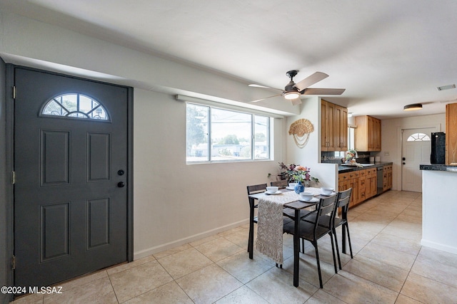 interior space with ceiling fan, sink, light tile patterned floors, and a healthy amount of sunlight