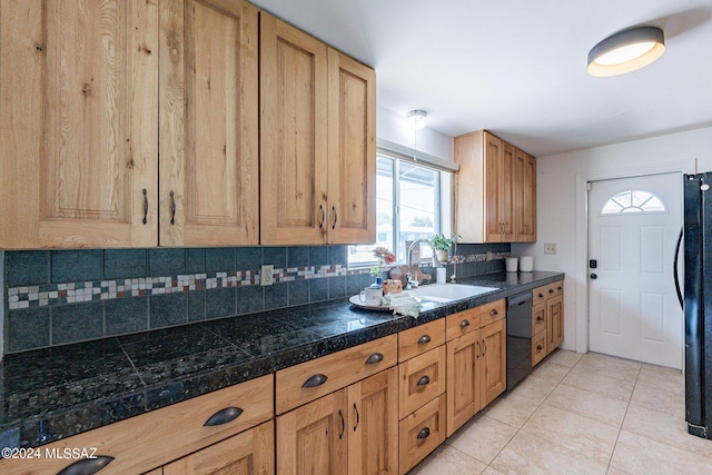 kitchen featuring decorative backsplash, black appliances, light tile patterned floors, and sink