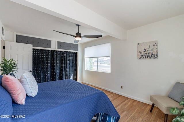 bedroom with ceiling fan, beam ceiling, and hardwood / wood-style floors