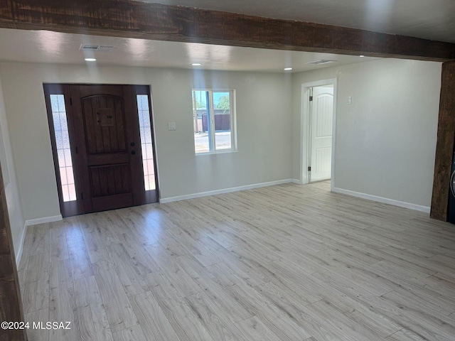 foyer featuring light wood-type flooring and beamed ceiling