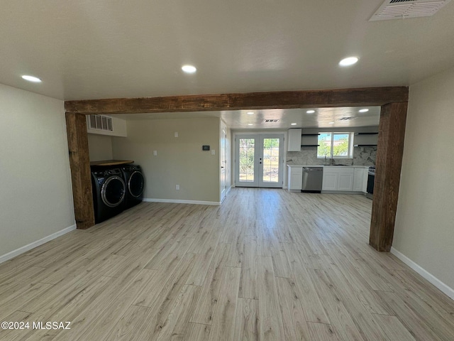 unfurnished living room with beamed ceiling, sink, french doors, light hardwood / wood-style flooring, and washer and clothes dryer