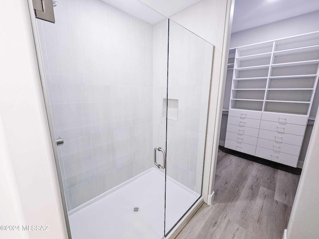 bathroom with hardwood / wood-style floors and an enclosed shower