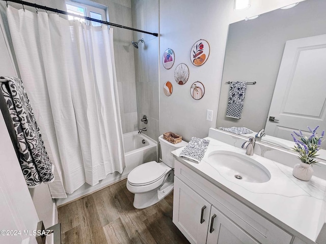 full bathroom with shower / tub combo with curtain, hardwood / wood-style floors, vanity, and toilet