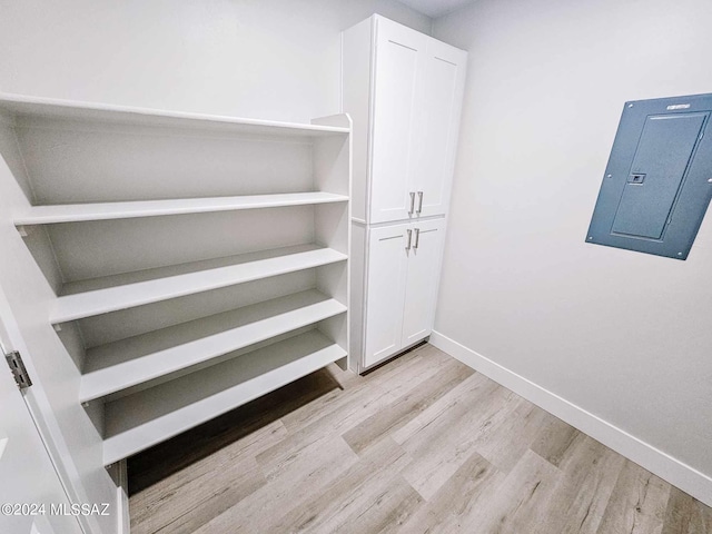 walk in closet featuring light wood-type flooring and electric panel