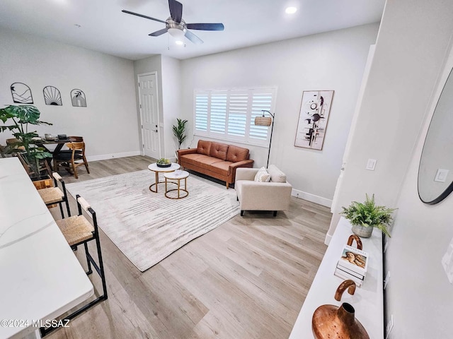 living room featuring light wood-type flooring and ceiling fan