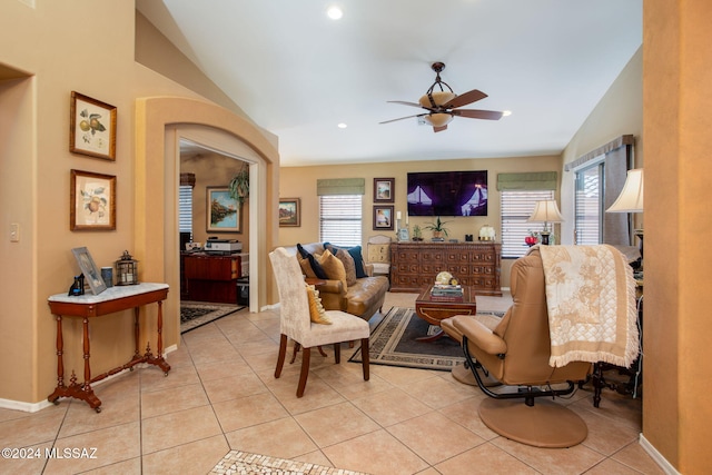 tiled living room featuring ceiling fan, lofted ceiling, and a wealth of natural light