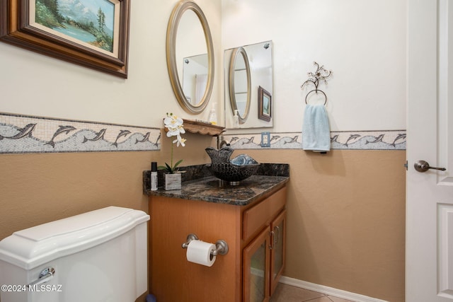 bathroom with toilet, vanity, and tile patterned floors