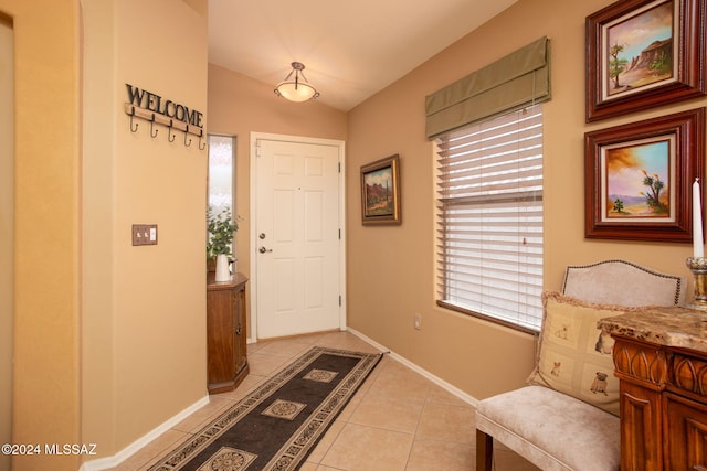 tiled entrance foyer featuring lofted ceiling