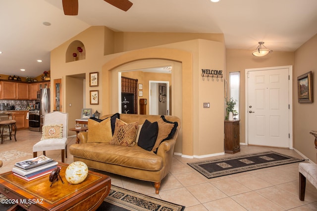 living room with ceiling fan, lofted ceiling, and light tile patterned floors