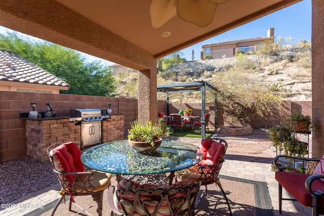 view of patio featuring area for grilling, grilling area, and ceiling fan