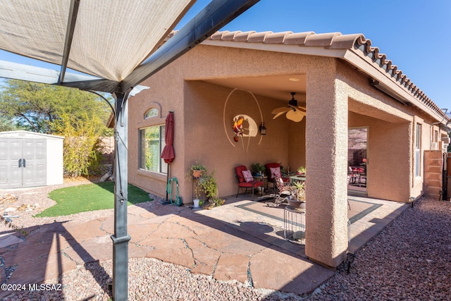 view of patio / terrace featuring a shed and ceiling fan